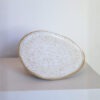 Prato Oval de cerâmica Esmo na cor branca salpicada, com borda em argila tabaco aparente.