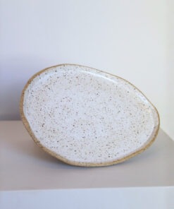 Prato Oval de cerâmica Esmo na cor branca salpicada, com borda em argila tabaco aparente.
