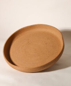 Prato Servir Orgânico de cerâmica verde Esmo, visto de ângulo, mostrando sua silhueta ampla e bordas elevadas.