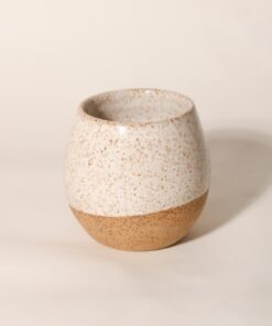 Copo Esmo de cerâmica com design autoral e acabamento em dois tons, argila natural e esmalte branco salpicado.